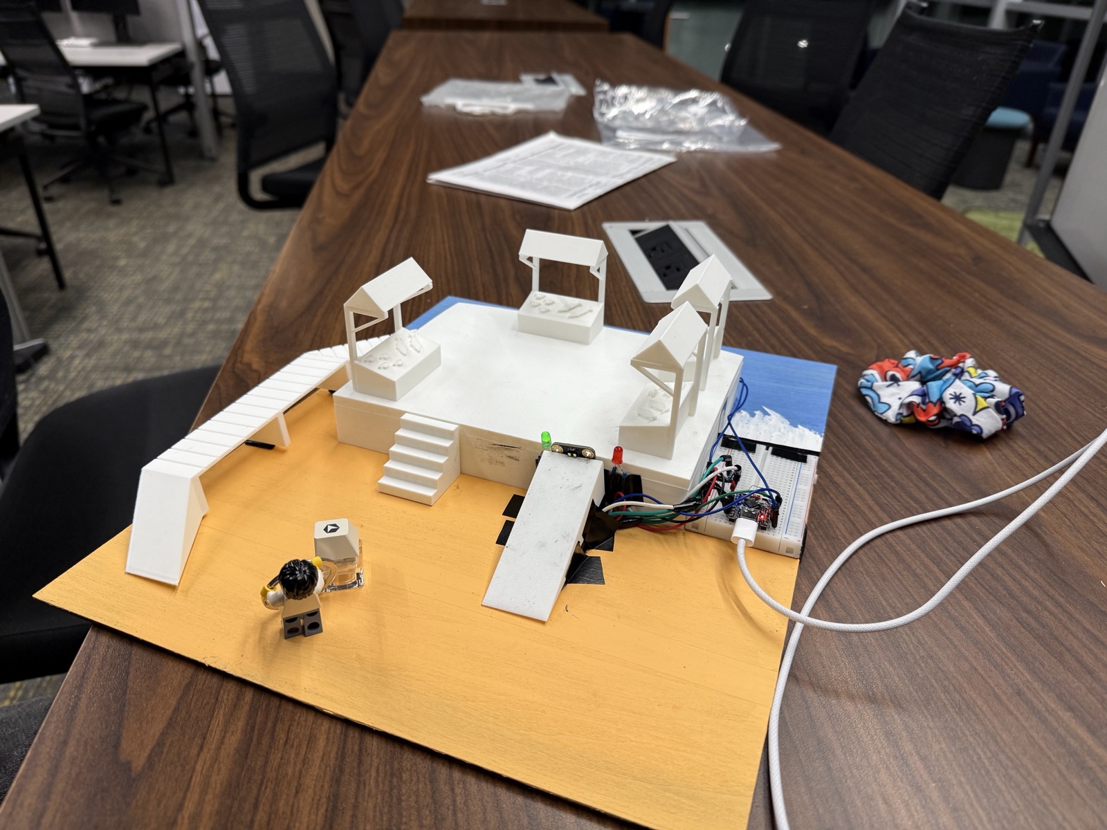 The physical miniature environment with its sensor, wiring, ramp, and market stalls